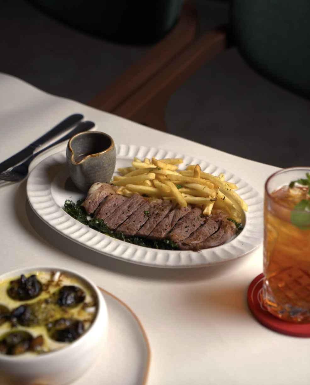 Écoute steak frites served with a glass of red wine