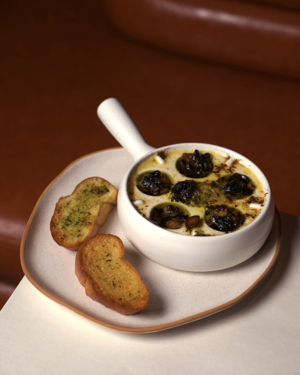Traditional escargot baked in garlic butter with two slices of toasted bread
