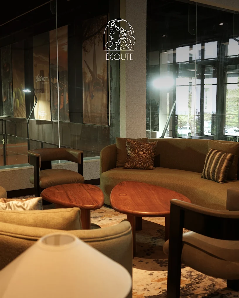 Écoute lounge seating beside the glass facade at Padeloom