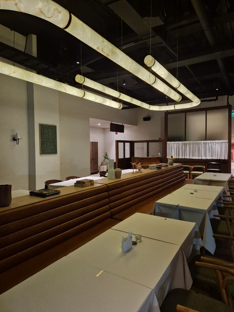 Écoute dining room with white-clothed tables and sculptural ceiling lights